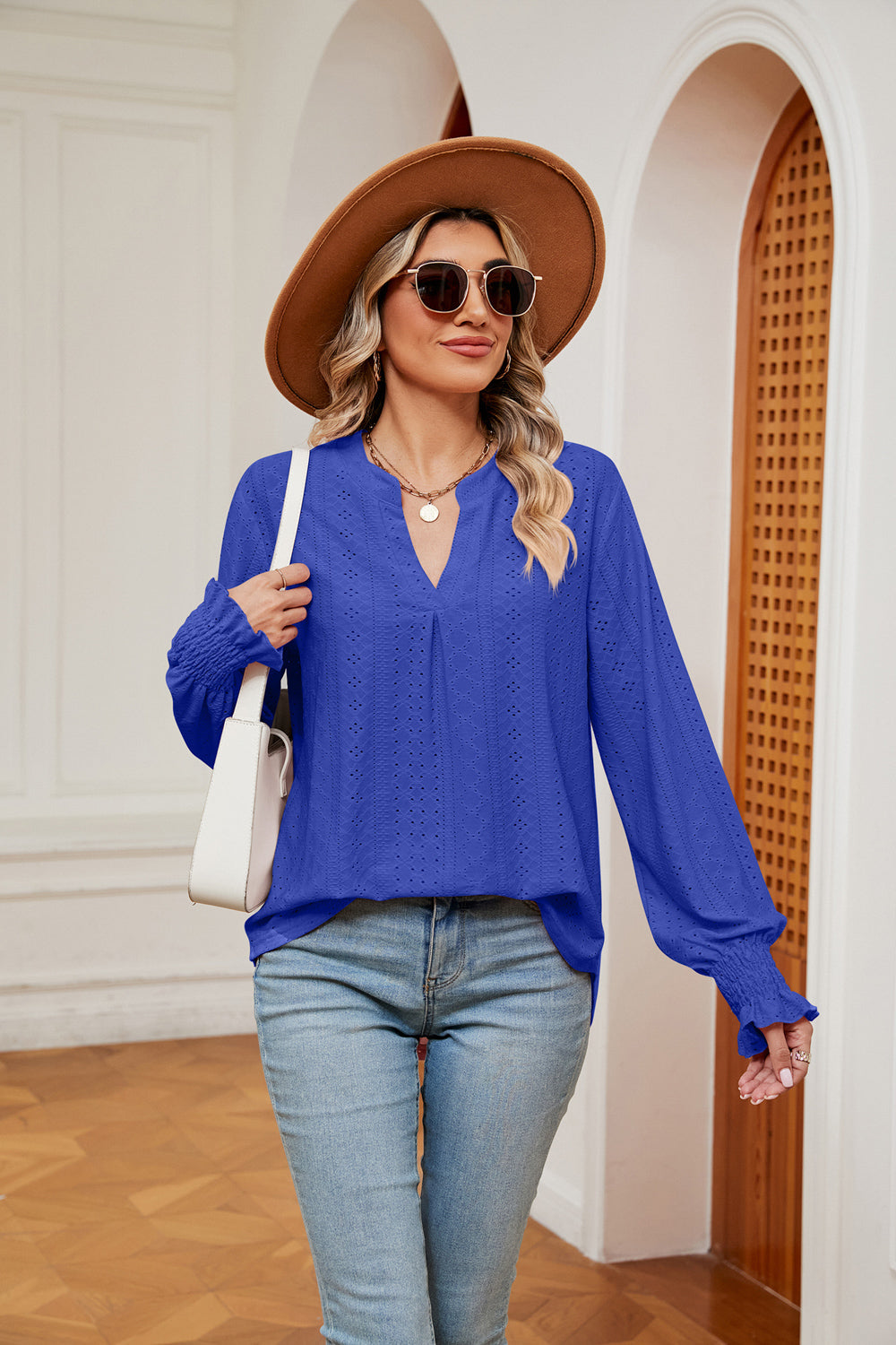 Royal blue eyelet detail blouse with V-neck and poet sleeves, cinched cuffs.