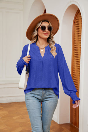 Royal blue eyelet detail blouse with V-neck and poet sleeves, cinched cuffs.