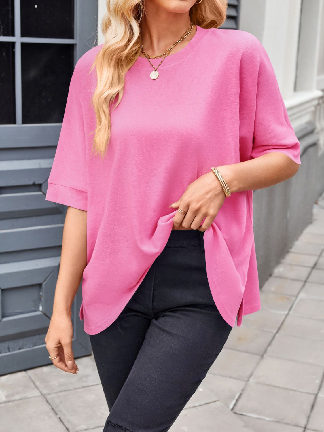 Pink relaxed fit t-shirt with drape sleeves and crew neck, styled with black pants.