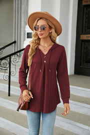 Textured henley hooded tunic in wine with button detail and drawstring hood.