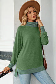 Colorblock raglan turtleneck tunic in green with grey accents, side slits, and a relaxed fit.