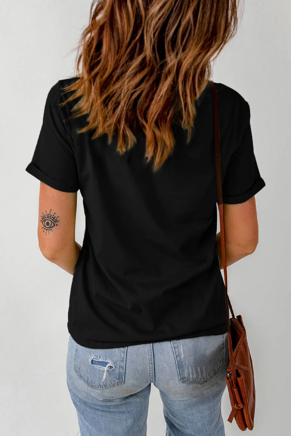 Black casual tee with rolled sleeves and an eye tattoo on the arm.