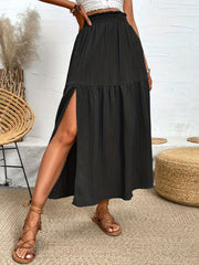 Black textured tiered maxi skirt with a high slit and smocked waist.