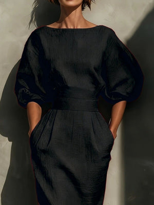Black midi dress with puff sleeves, boat neck, belted waist, and pockets.