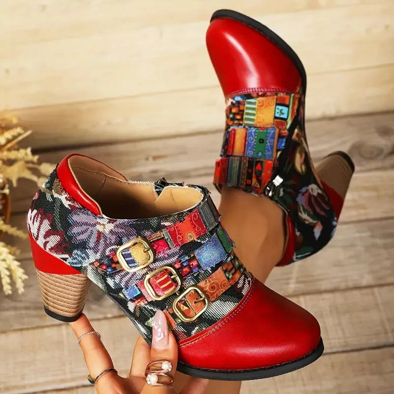 Red ankle boots with floral patchwork and triple buckle detail.