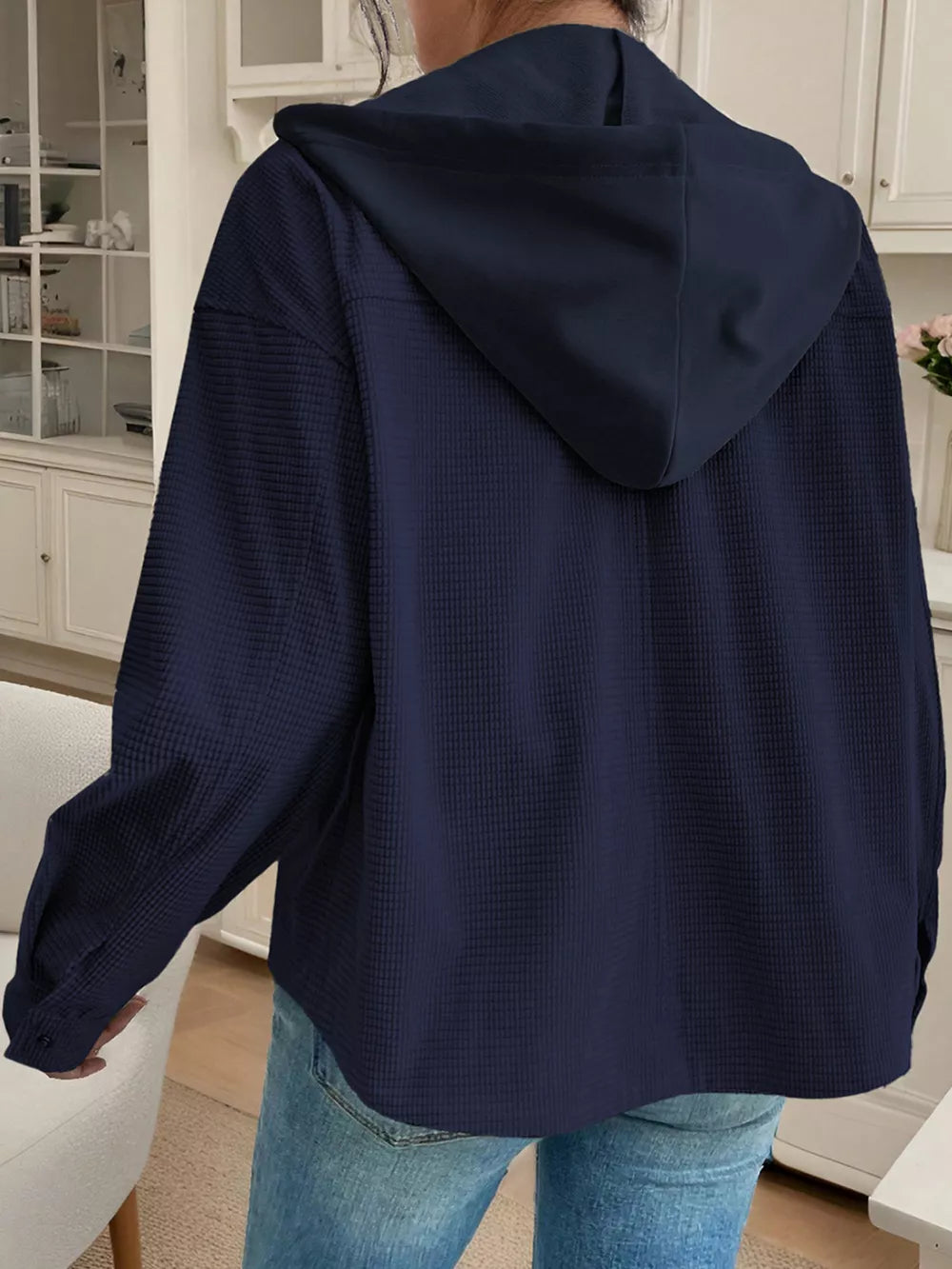 Dark navy waffle knit hooded jacket with buttoned cuffs and drawstring hood.