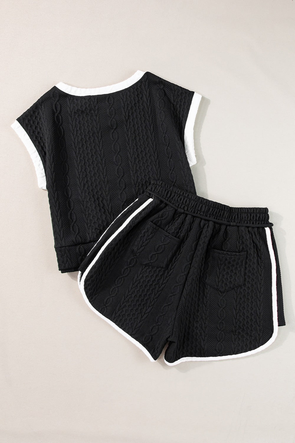 Black textured knit loungewear set with contrast trim on top and shorts.