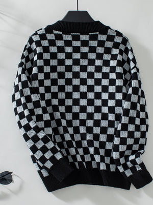 Checkerboard knit pullover sweater in black and white with a V-neck.