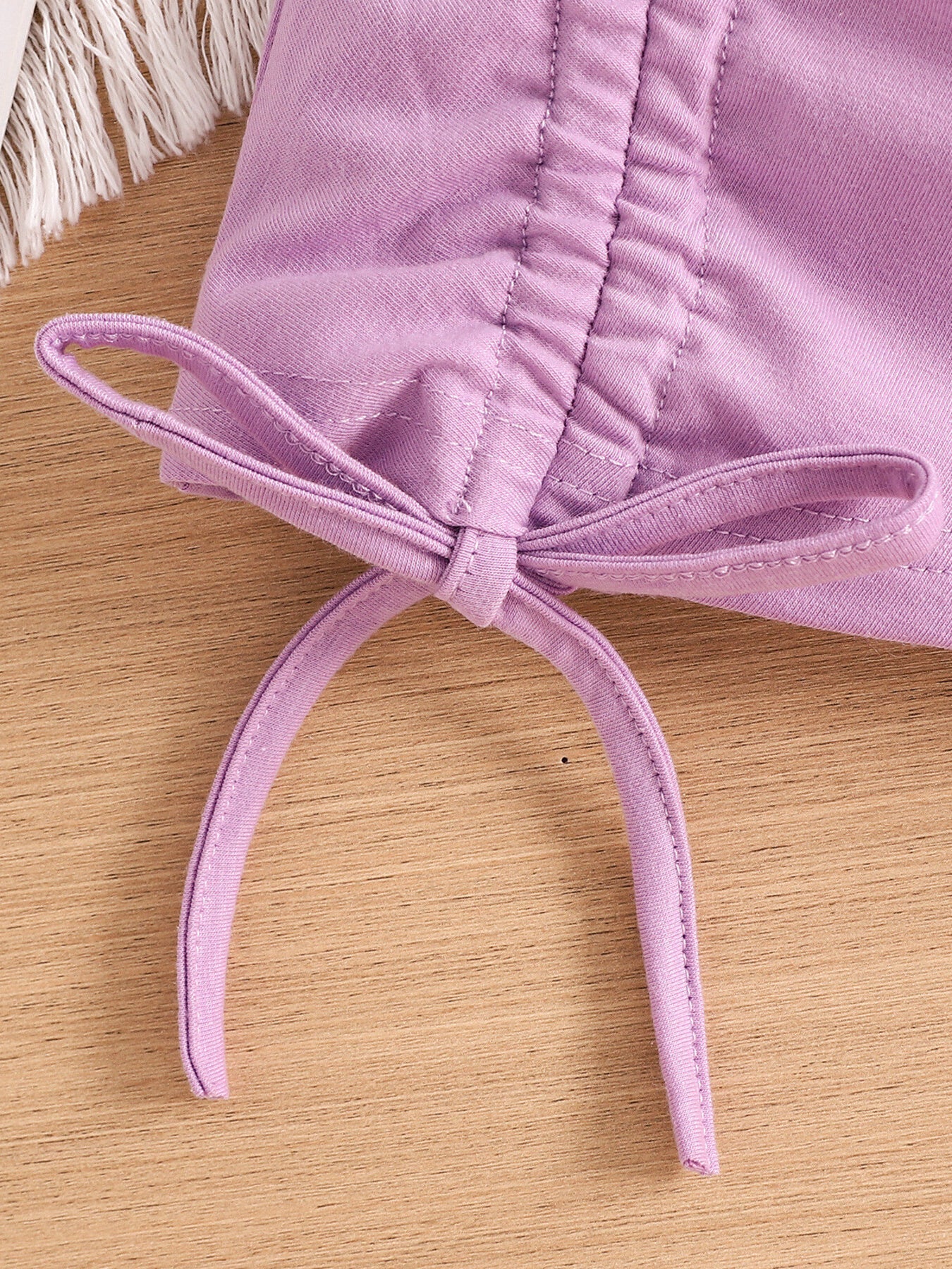 Violet toddler crop top with drawstring detail and bow.
