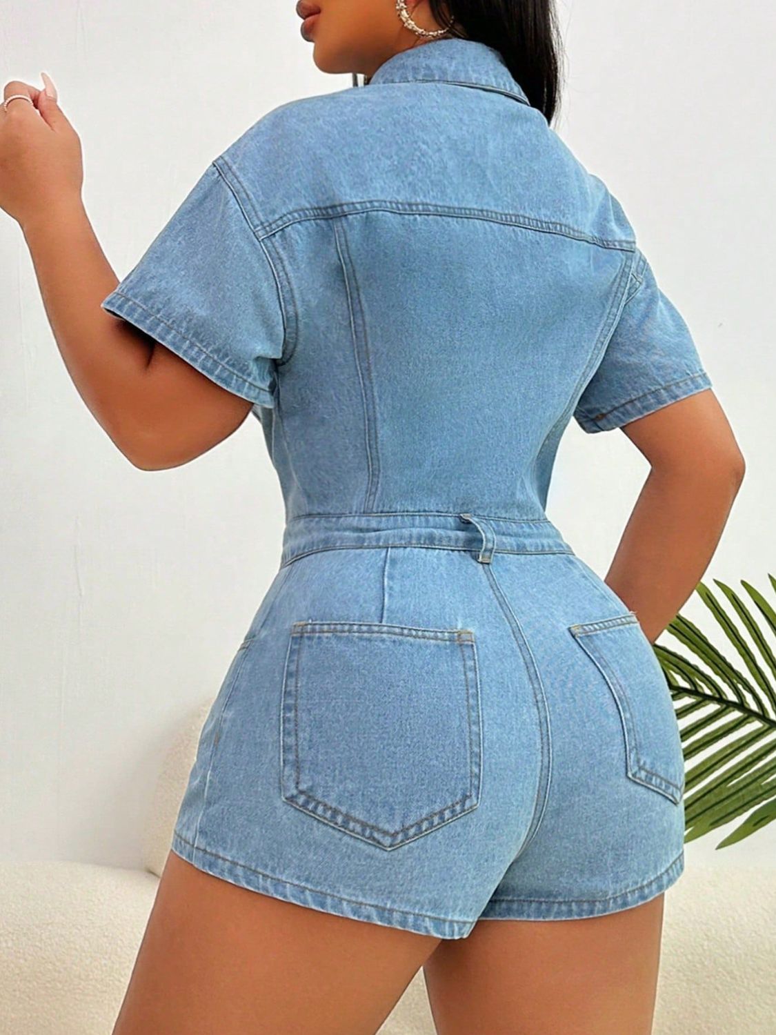 Light wash denim bustier romper with collared neckline, short sleeves, and buttoned front.