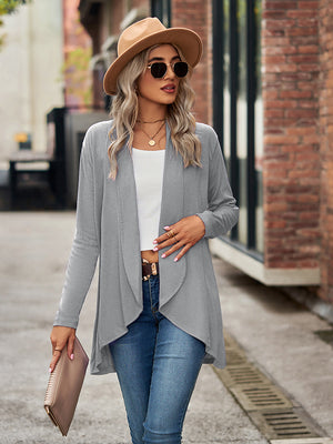 Draped cascade cardigan in cloudy blue with open front and asymmetrical hem, worn with jeans.