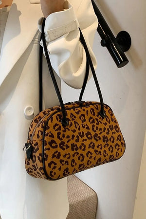Leopard print barrel bag in caramel with black trim and straps.