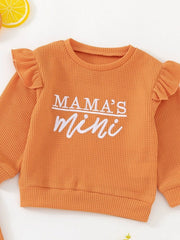 Orange waffle knit toddler top with ruffled sleeves and "Mama's mini" embroidery.