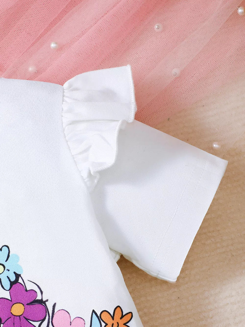 White baby set with floral print and ruffled short sleeves.