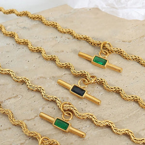 Gold rope chain necklaces with emerald bar pendants in dark green and black.