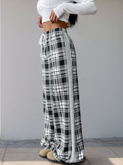 Plaid wide-leg track pants in black with white and gray plaid pattern and a gray side stripe.
