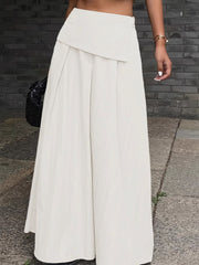 Pleated high-waisted maxi skirt in ivory with button detail and asymmetrical overlay.
