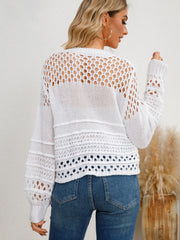 White openwork knit sweater with textured details and long sleeves.
