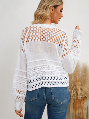 White openwork knit sweater with textured details and long sleeves.