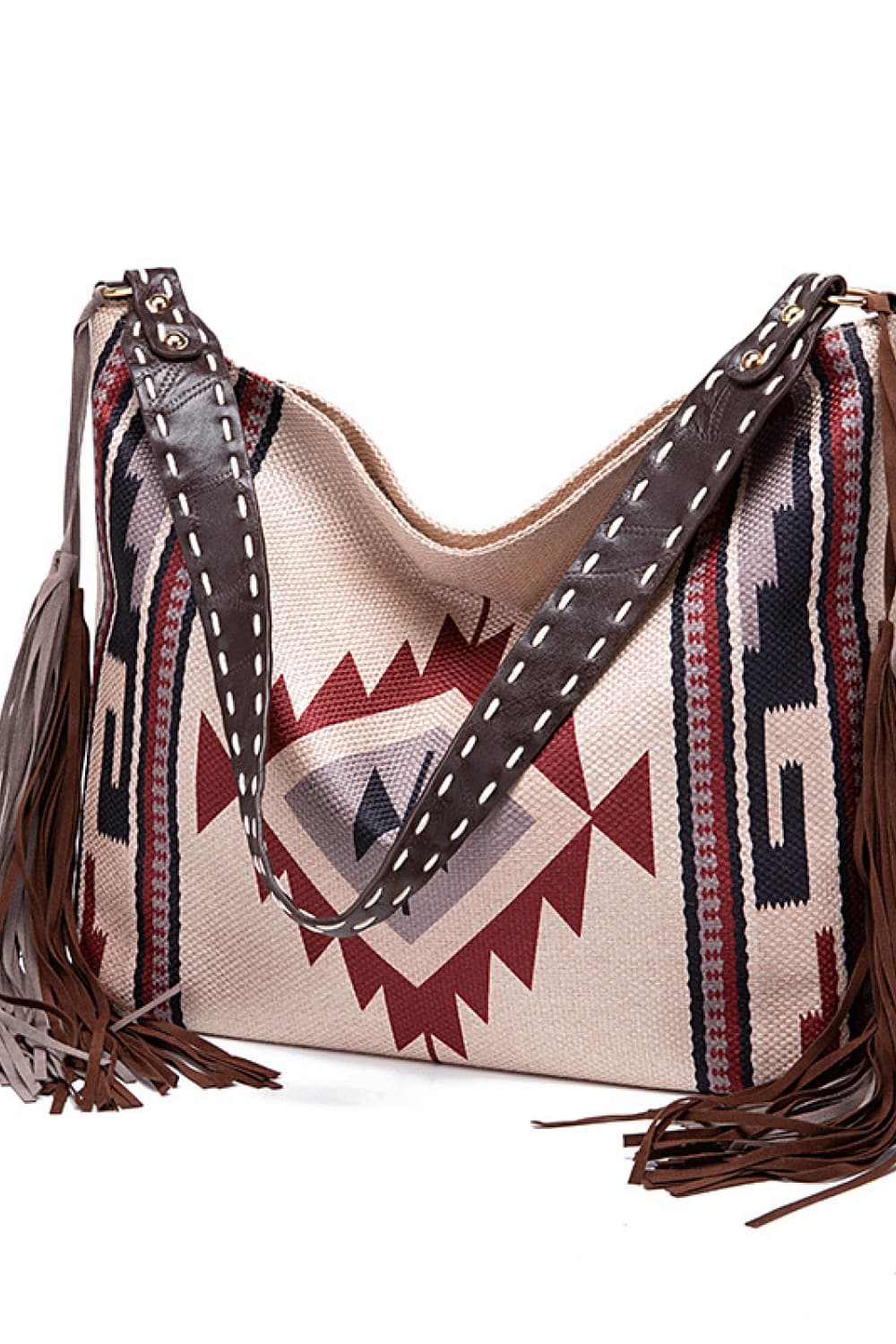 Southwestern fringe hobo bag in beige canvas with geometric pattern and leather straps.