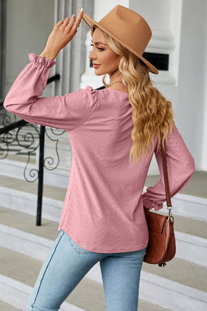 Pink textured puff sleeve blouse with ruffle cuffs and a square neckline.