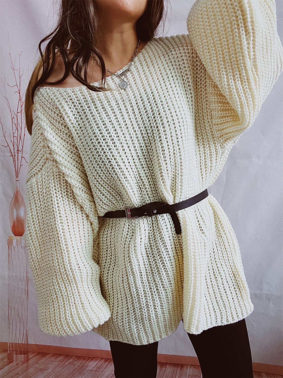 Oversized ribbed knit sweater in beige with a belted waist and off-the-shoulder neckline.