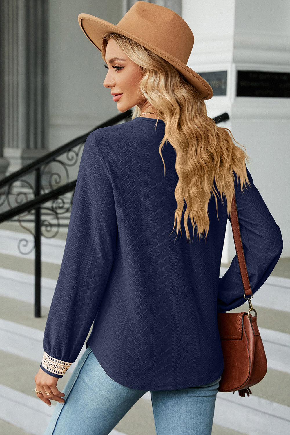 Dark blue textured V-neck blouse with lace trim on cuffs.