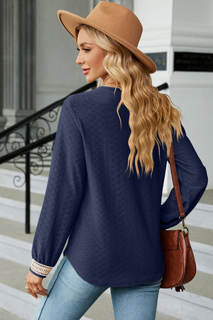 Dark blue textured V-neck blouse with lace trim on cuffs.