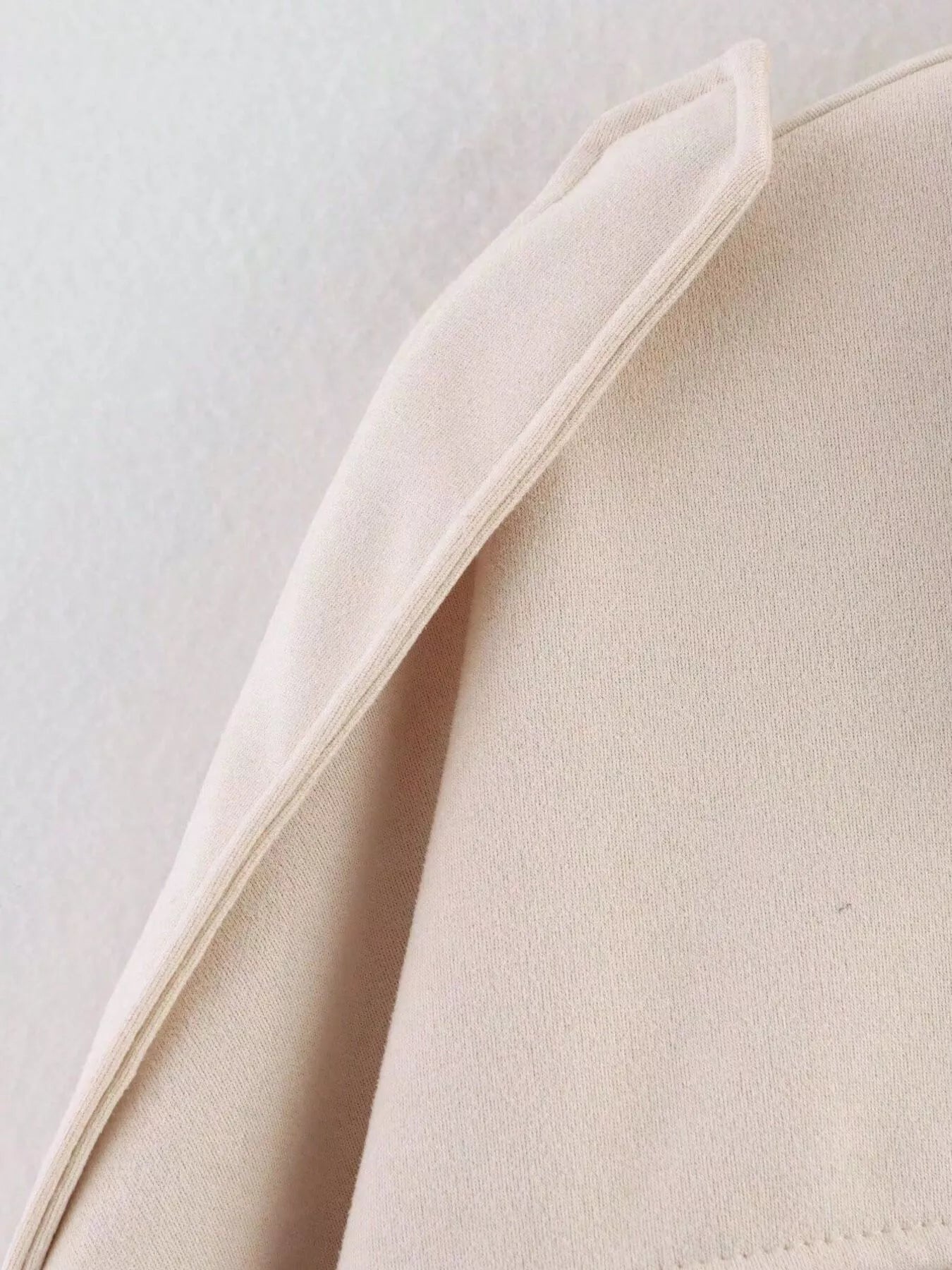 Oversized zip-up jacket in off-white with a textured knit fabric and folded collar detail.