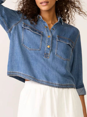 Blue denim cropped half snap shirt with two chest pockets and gold buttons.