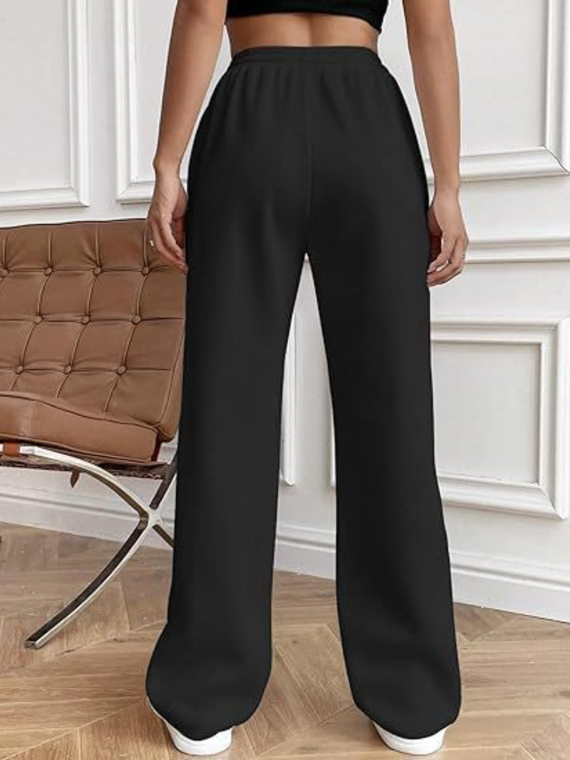 Black pleated wide-leg lounge trousers with a relaxed fit.