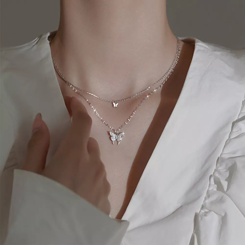 Elegant double-layer necklace with butterfly charms in white gold color.