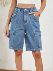 Denim cargo bermuda shorts in medium wash with buttoned pockets and elastic waist.