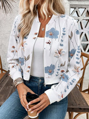 White botanical print bomber jacket with blue and tan flowers, zip front, ribbed cuffs and hem.