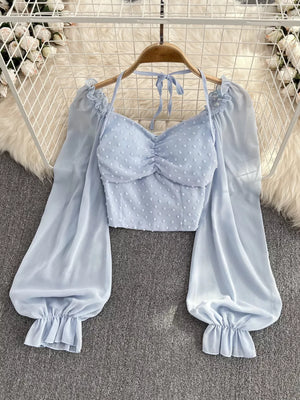 Blue Swiss dot maternity blouse with ruched sweetheart neckline and ruffled balloon sleeves.