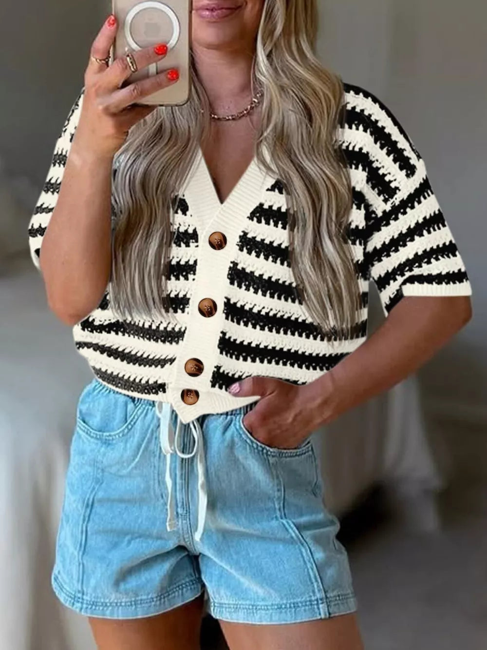 Cropped black and white striped knit cardigan with V-neck and button front.
