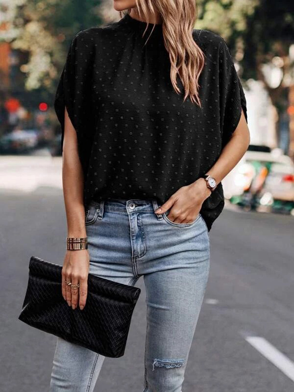Black textured dot back-tie blouse with short sleeves and mock neck.