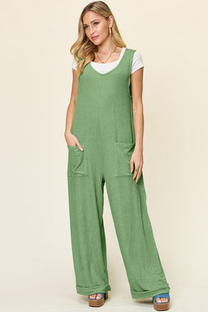 Light green ribbed knit tie-strap jumpsuit with wide legs and front pockets.