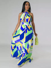 Halter neck maxi dress with bold geometric print, defined waistband, and pleated skirt.
