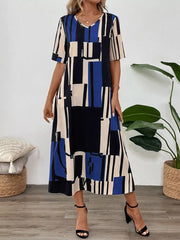 Geometric V-neck midi dress in blue, black, and cream abstract print with short sleeves.
