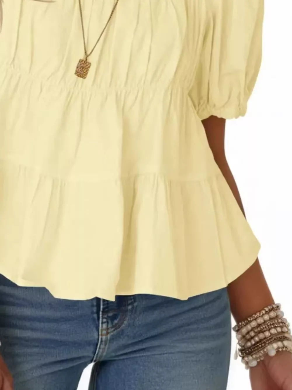 Light yellow maternity blouse with puff sleeves, ruffled tiers, and smocked bodice detail.