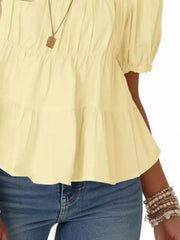 Light yellow maternity blouse with puff sleeves, ruffled tiers, and smocked bodice detail.