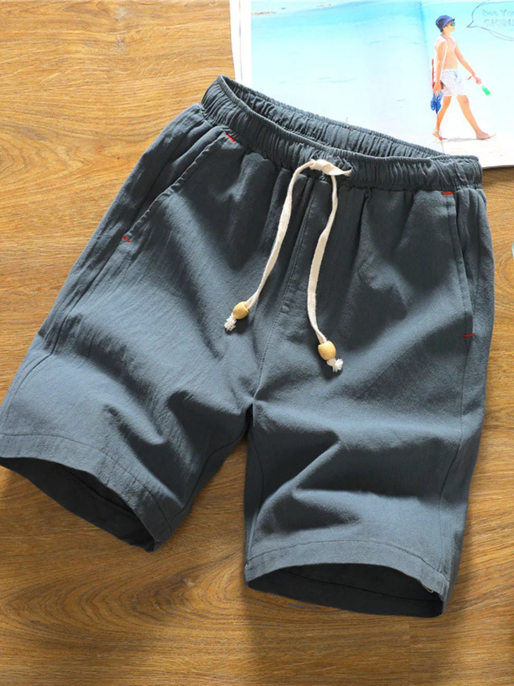 Grey relaxed fit drawstring chino shorts with wooden bead details on the tie.