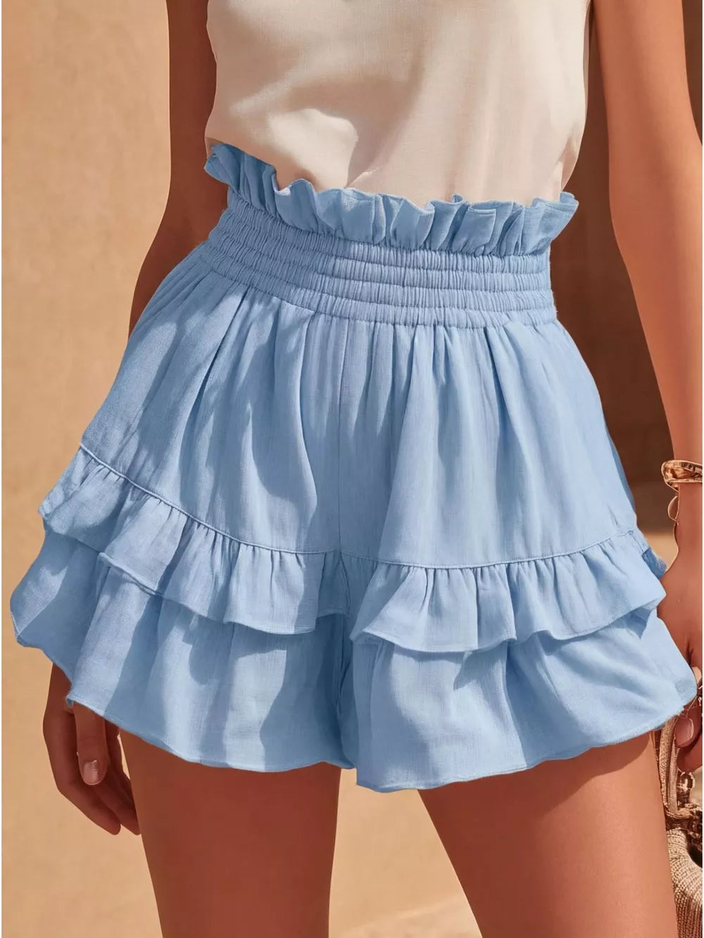 Sky blue ruffled high-waisted shorts with smocked waistband and tiered hem.