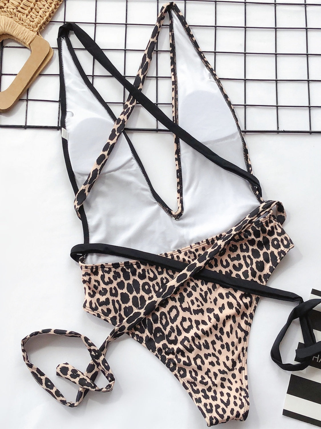 Leopard print one-piece swimsuit with plunging neckline and wrap detail straps.