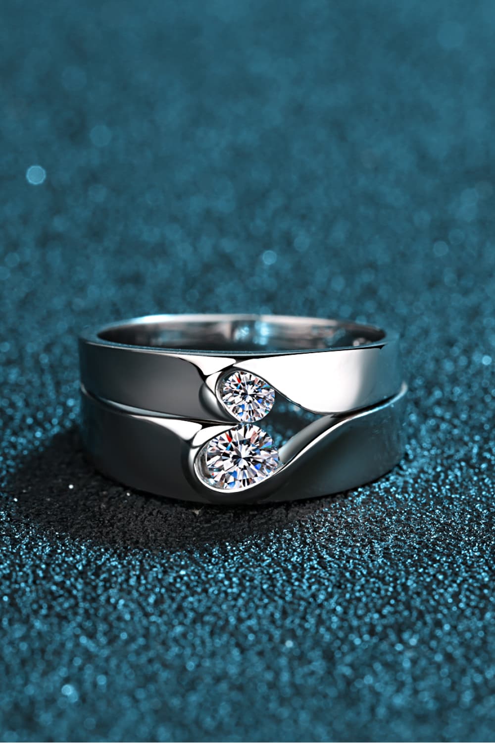 Curved Embrace diamond ring set for men and women, featuring two intertwined silver bands with sparkling cubic zirconia