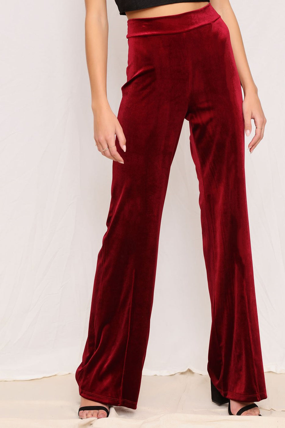 Plush velvet wide-leg trousers in burgundy with a high waist.