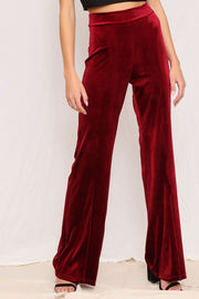 Plush velvet wide-leg trousers in burgundy with a high waist.
