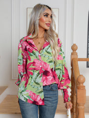 Blooms & Buttons shirt in light blue with a vibrant floral print, collared neckline, and buttoned front.