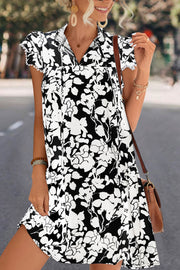 Black floral print trapeze dress with tie-neck and butterfly sleeves.